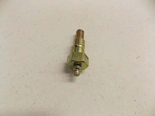 A small brass valve or fitting on a white surface.