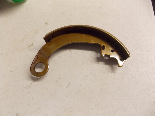A curved metallic component with a hole and notch, possibly a mechanical part.
