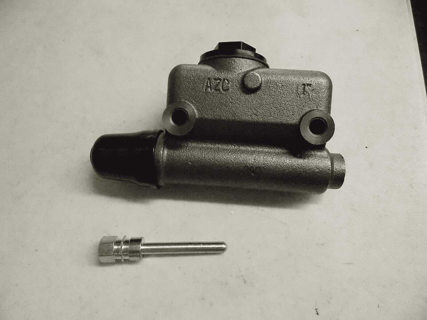 Two metal mechanical parts on a white surface.
